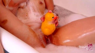 Sexy babe masturbeert haar poesje met een rubberen eendje in bubbelbad